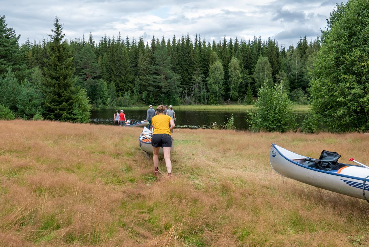 Van de weg het laatste stukje door een veld naar een rivier, hier konden we de kano's zo het water in rijden (Bas Wetter)